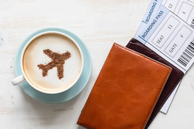 Wallet on a table with flight tickets and a mug of coffee
